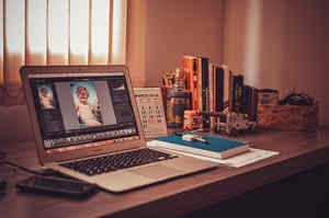 A desk on which a laptop and other office utensils are placed.